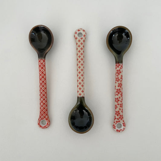 handmade small Japanese pottery spoon for coffee or tea in red and cream dot, cross, and flower patterns