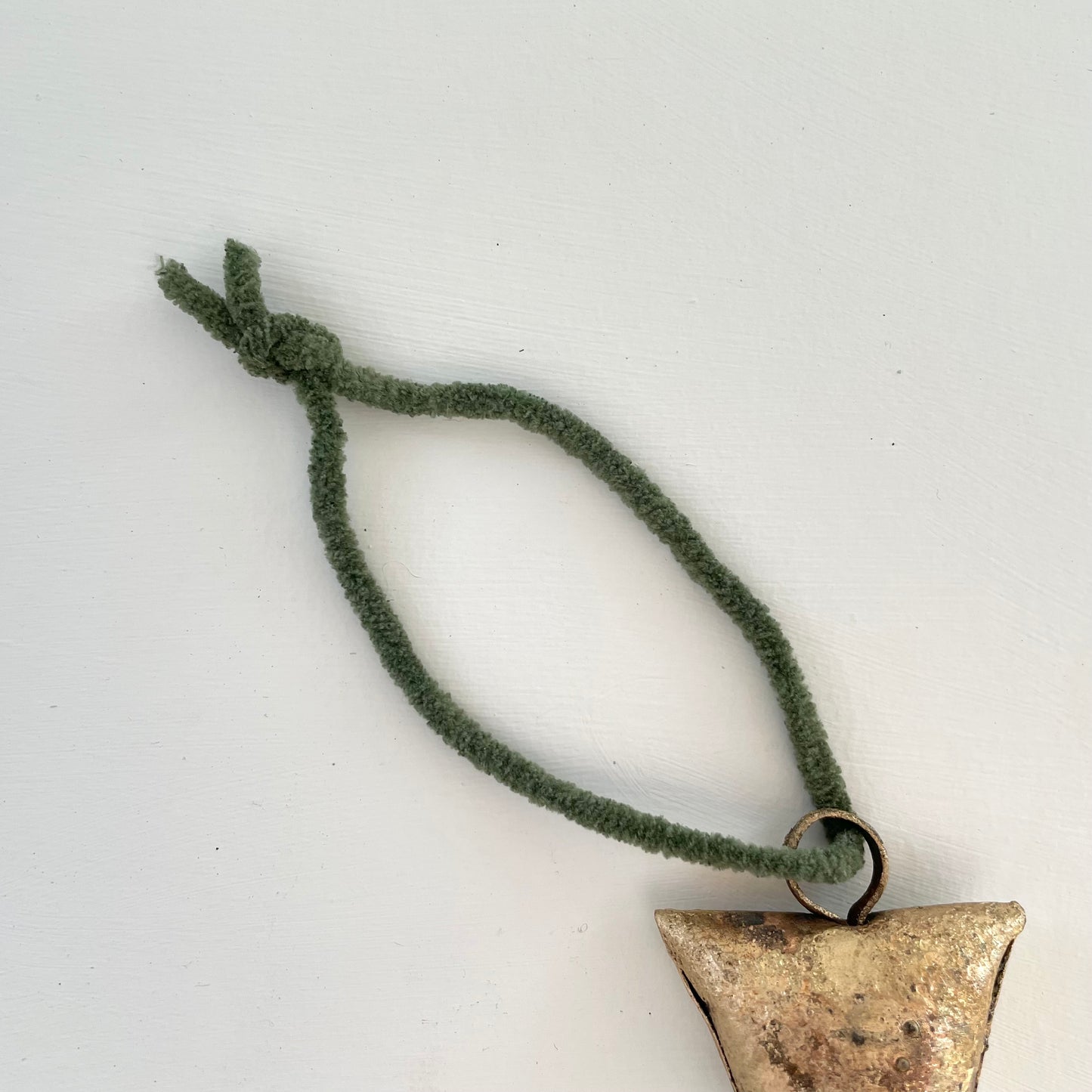 ornaments made out of trapezoid shaped tin bells with brass finish and metal striker with hunter green suede cord