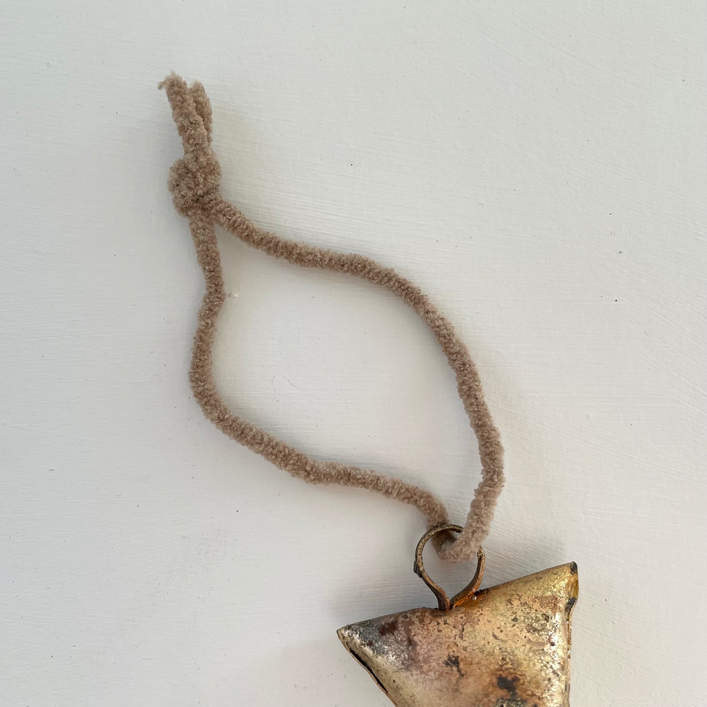 ornaments made out of trapezoid shaped tin bells with brass finish and metal striker with tan suede cord
