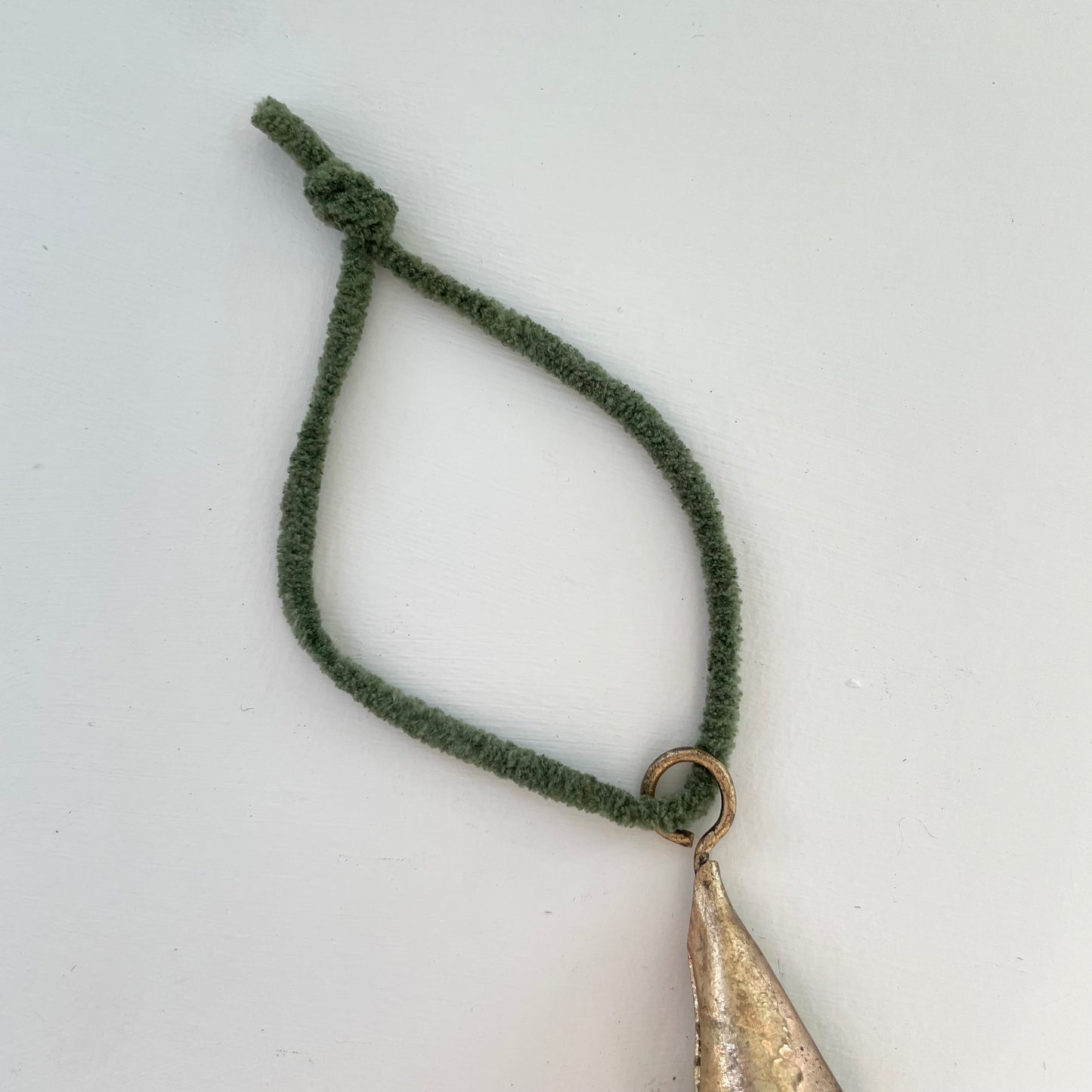 tiny 2 inch cone shaped tin bells with brass finish Christmas holiday ornaments on hunter green suede cord