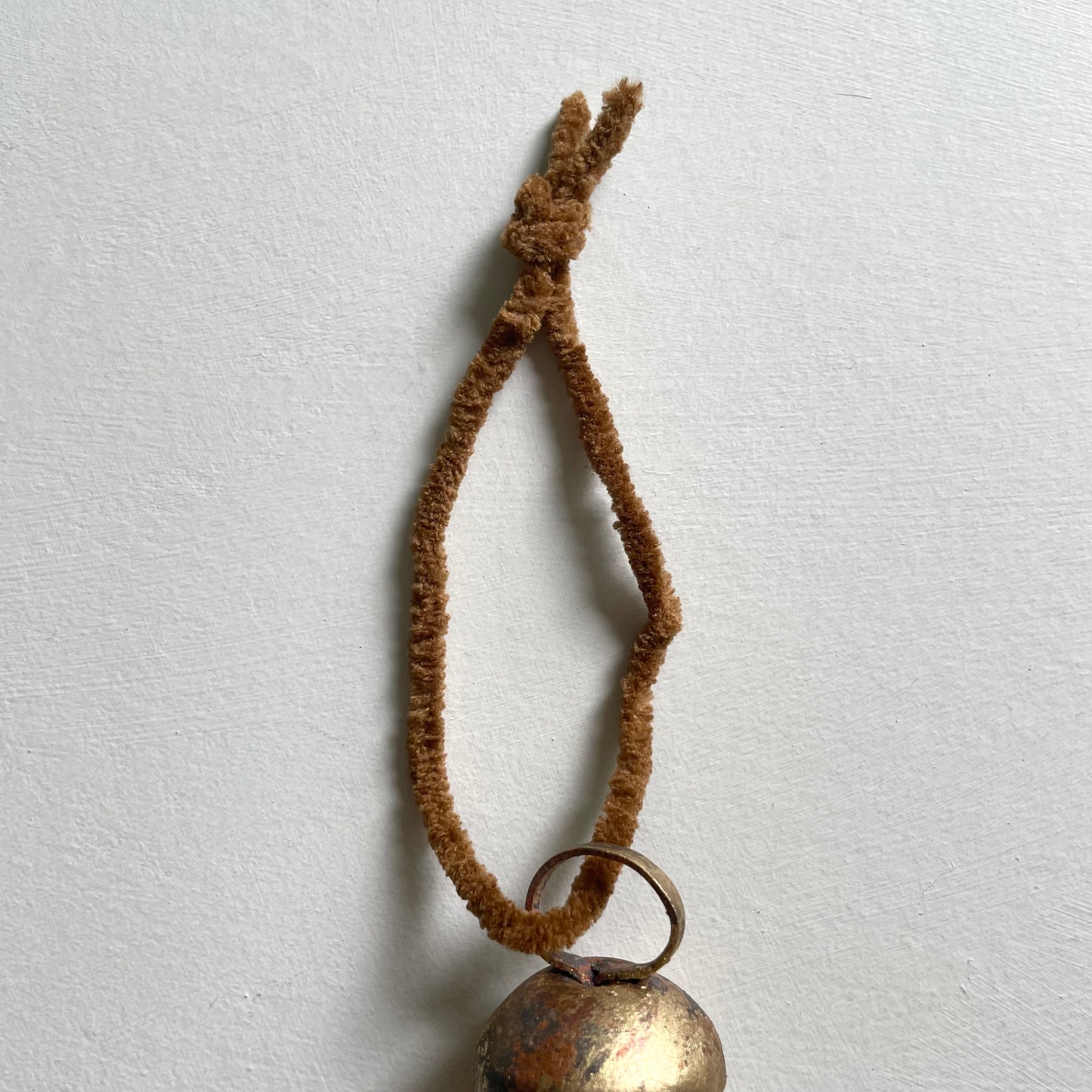 tiny rounded top tin bells with brass finish Christmas holiday ornaments on cognac brown chenille cord