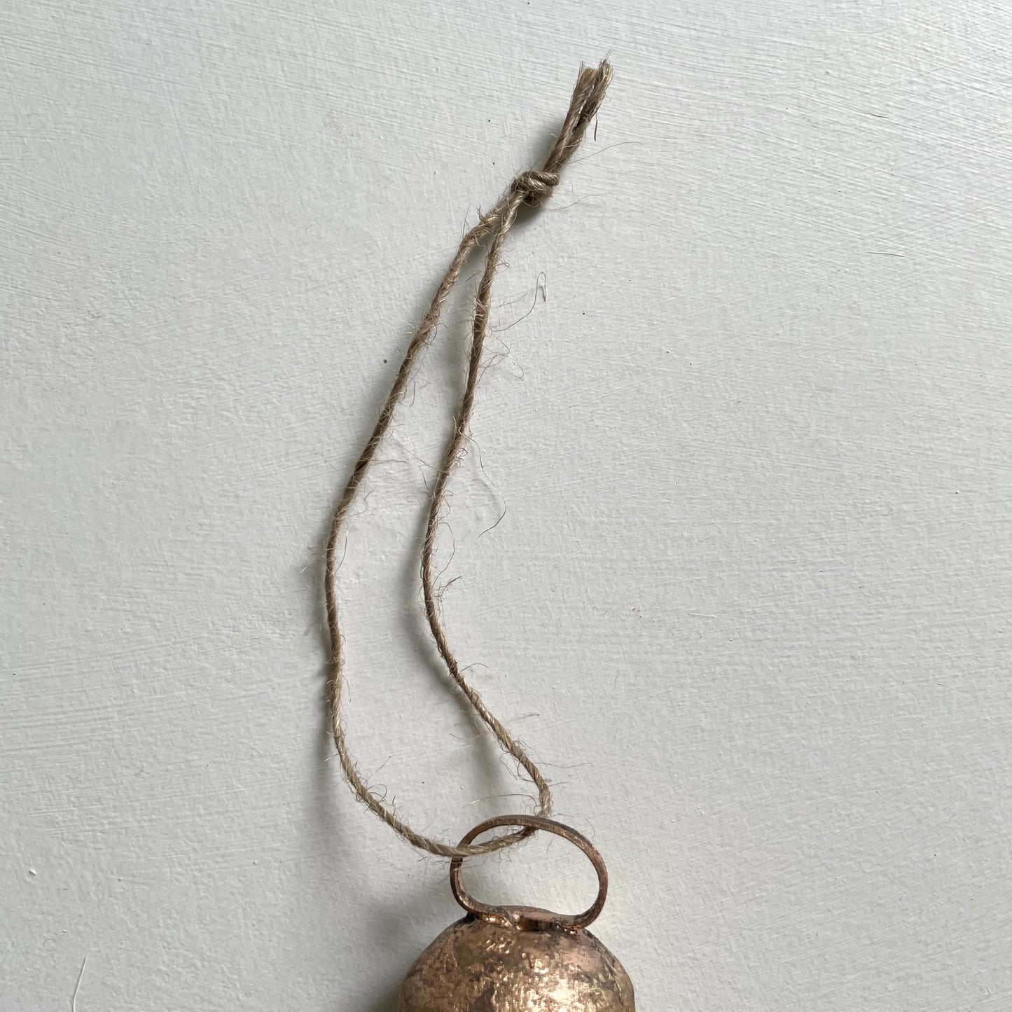 tiny rounded top tin bells with brass finish Christmas holiday ornaments on jute