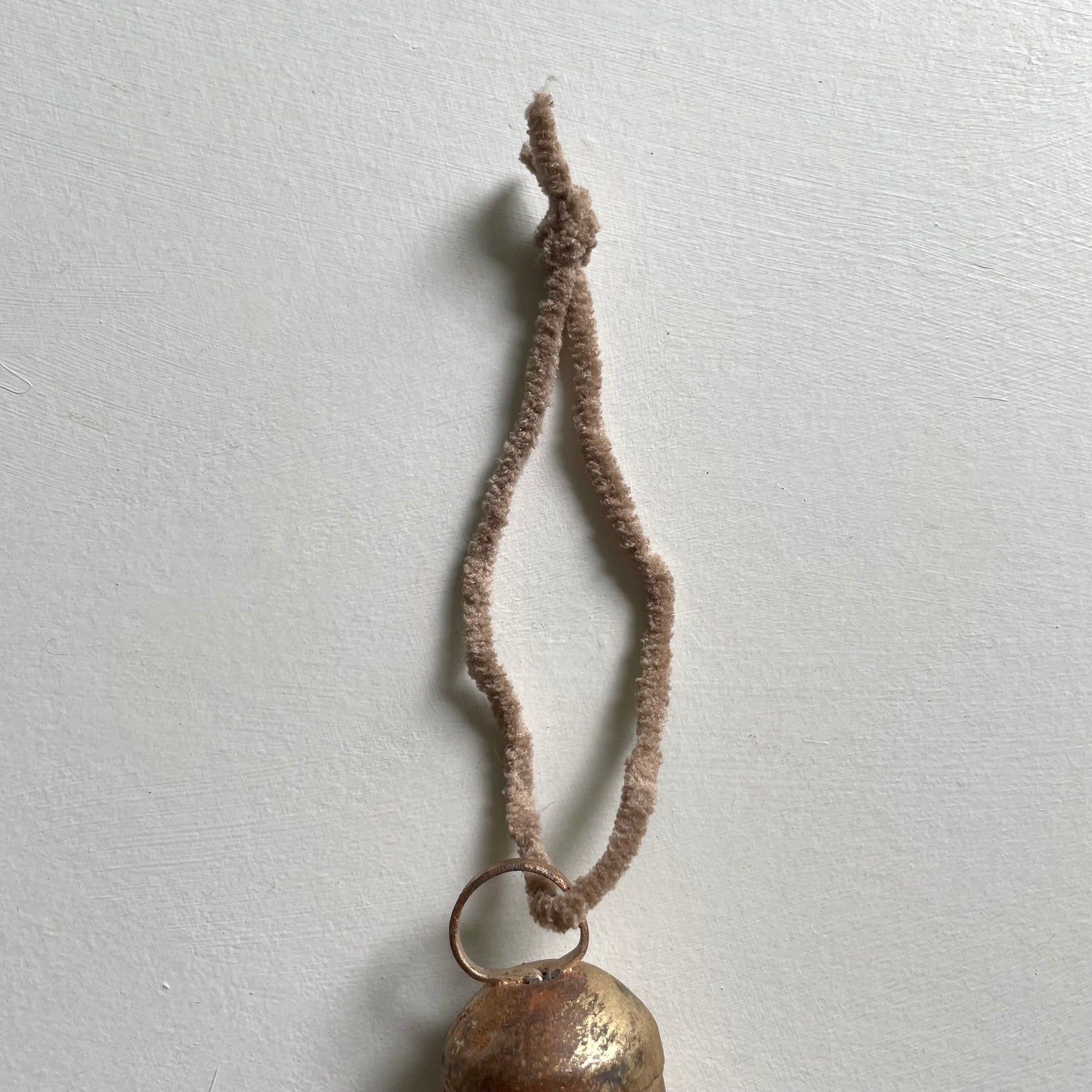 tiny rounded top tin bells with brass finish Christmas holiday ornaments on tan chenille cord