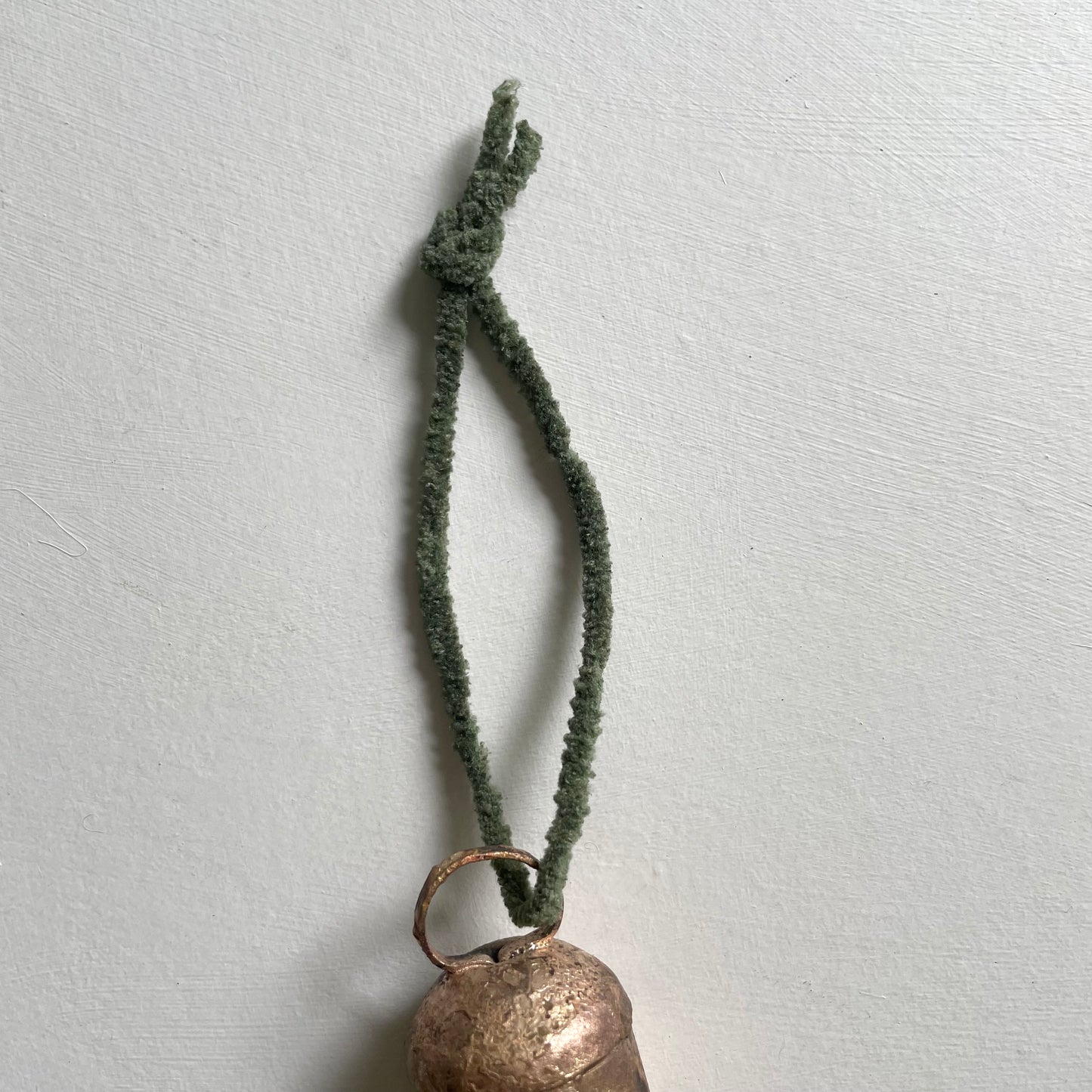 tiny rounded top tin bells with brass finish Christmas holiday ornaments on hunter green chenille cord
