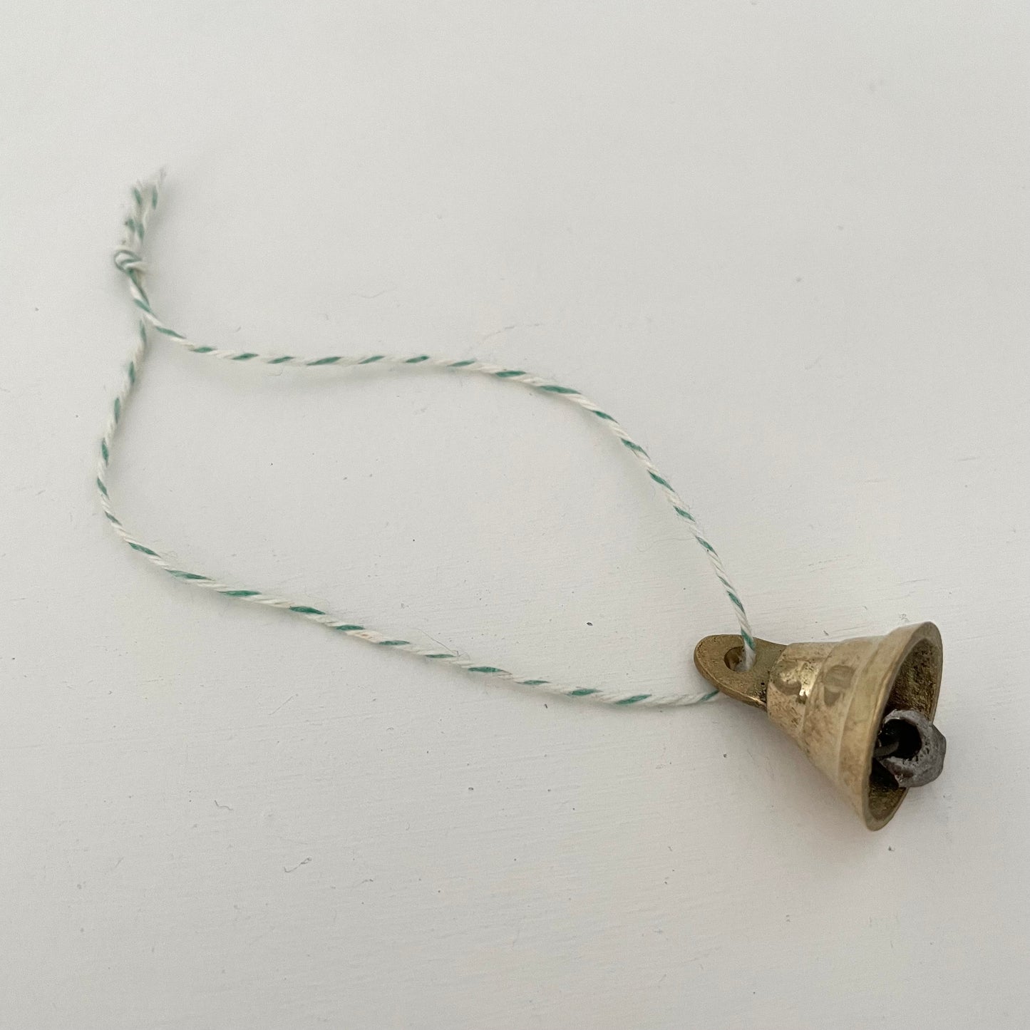 7/8" mini brass flared bell ornament on striped green and white bakers twine