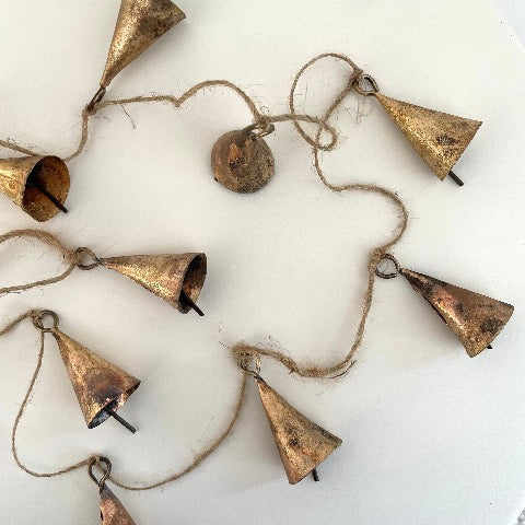 2 inch cone shaped tin bells with a brass finish strung on jute for a garland