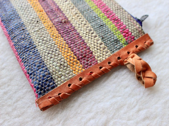 multi-colored muted striped raffia woven zippered clutch with leather trim bohemian