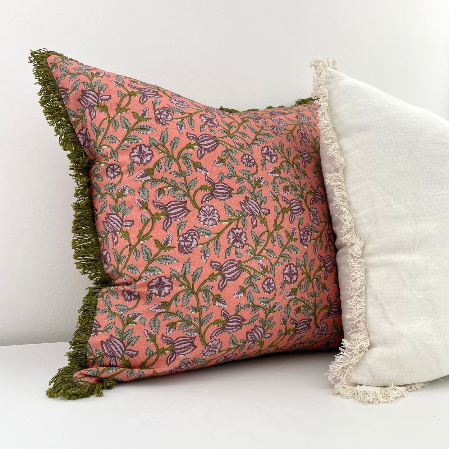 pink and green floral pillow cover with fringed edges and off white linen pillow cover