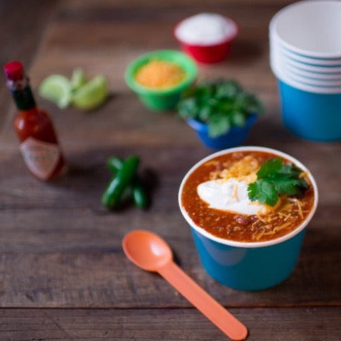 chunky plastic disposable full size party spoons in a rainbow of colors with chili in 16 ounce paper party bowls