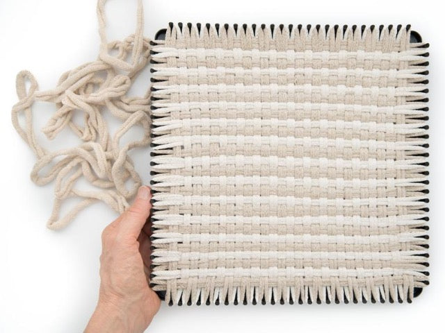 handmade 100 percent cotton geometric woven potholder or trivet on the loom for a farmhouse kitchen