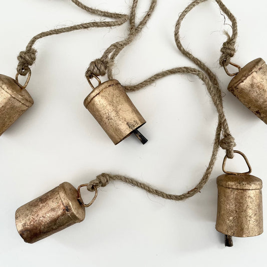 rustic brass finish cluster of 6 bells hanging on a jute string for holiday Christmas decor