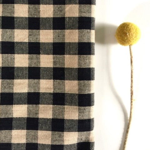 black and tan gingham check 100 percent cotton farmhouse kitchen utilitarian towel with billy ball flower stem next to it