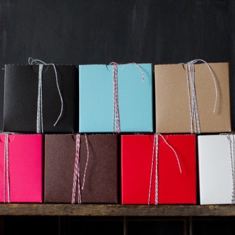 4x4 square bakery boxes in a stack wrapped with striped bakers twine 