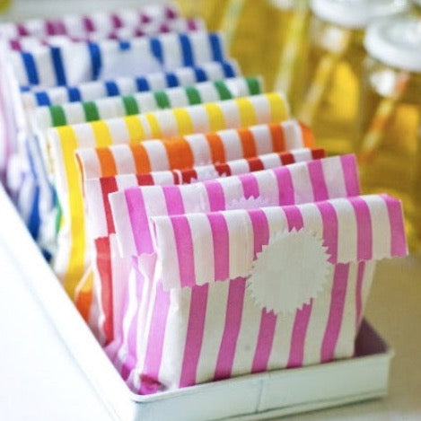 rainbow striped paper candy treat and gift favor bags with white starburst sticker label