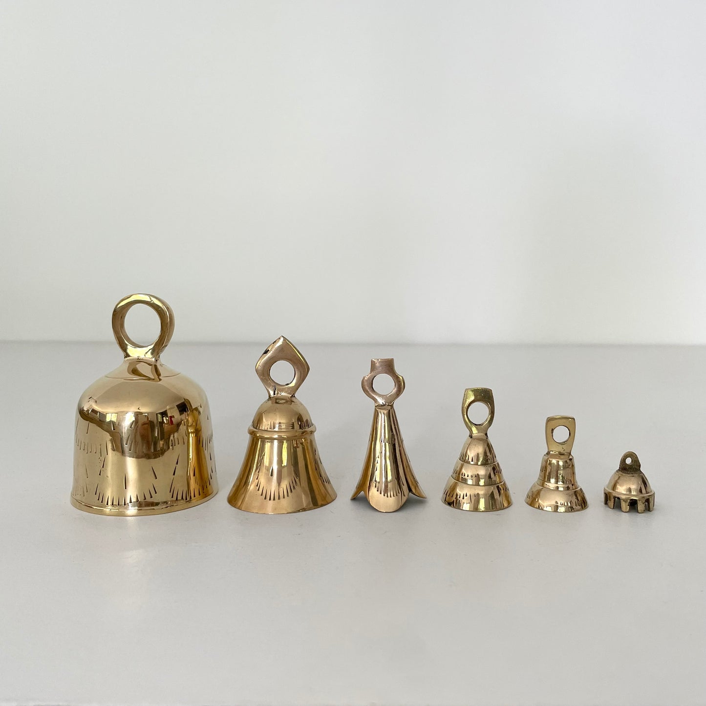 range of brass flared and tulip collector bells w/ metal striker