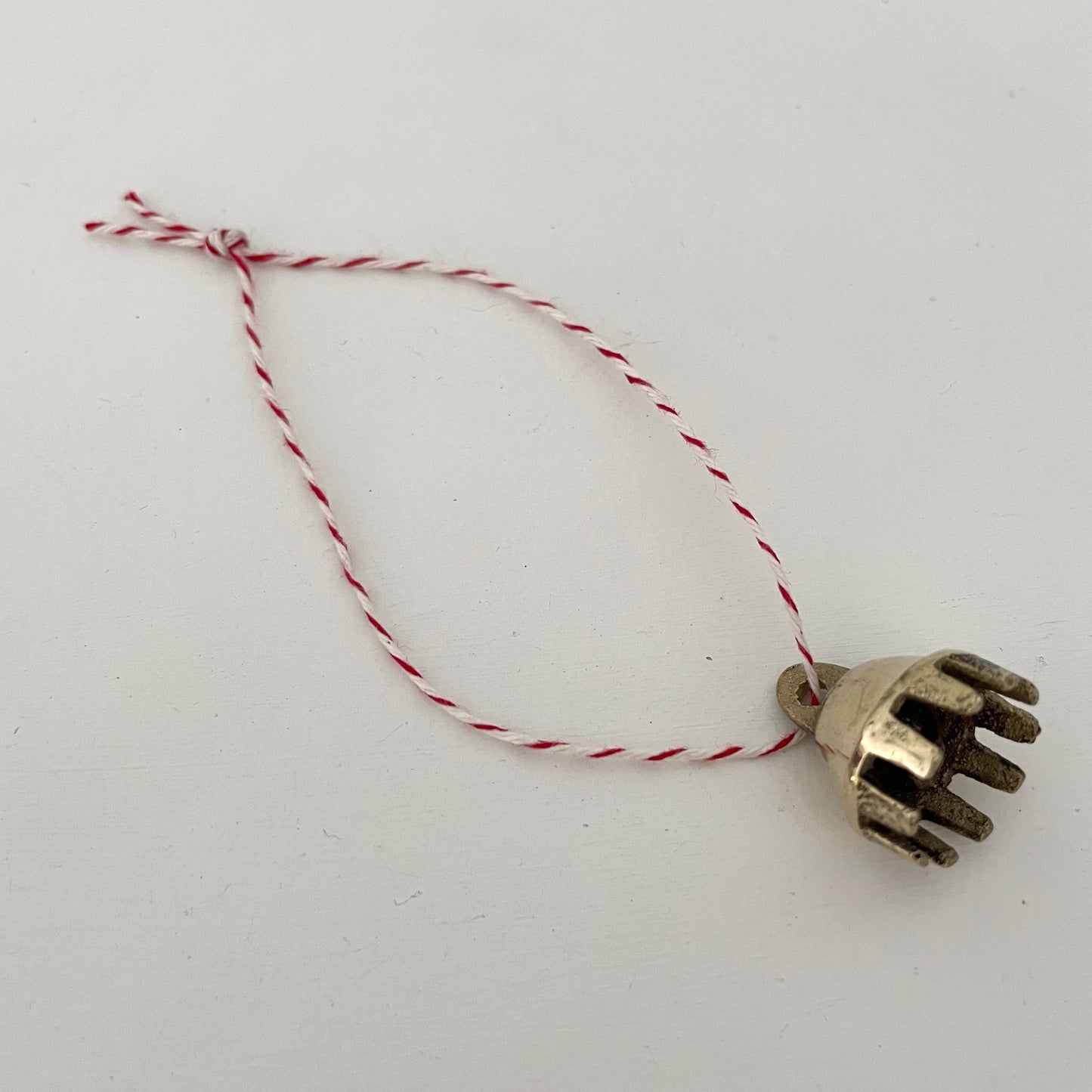 7/8" mini brass claw bell ornament on red and white striped bakers twine