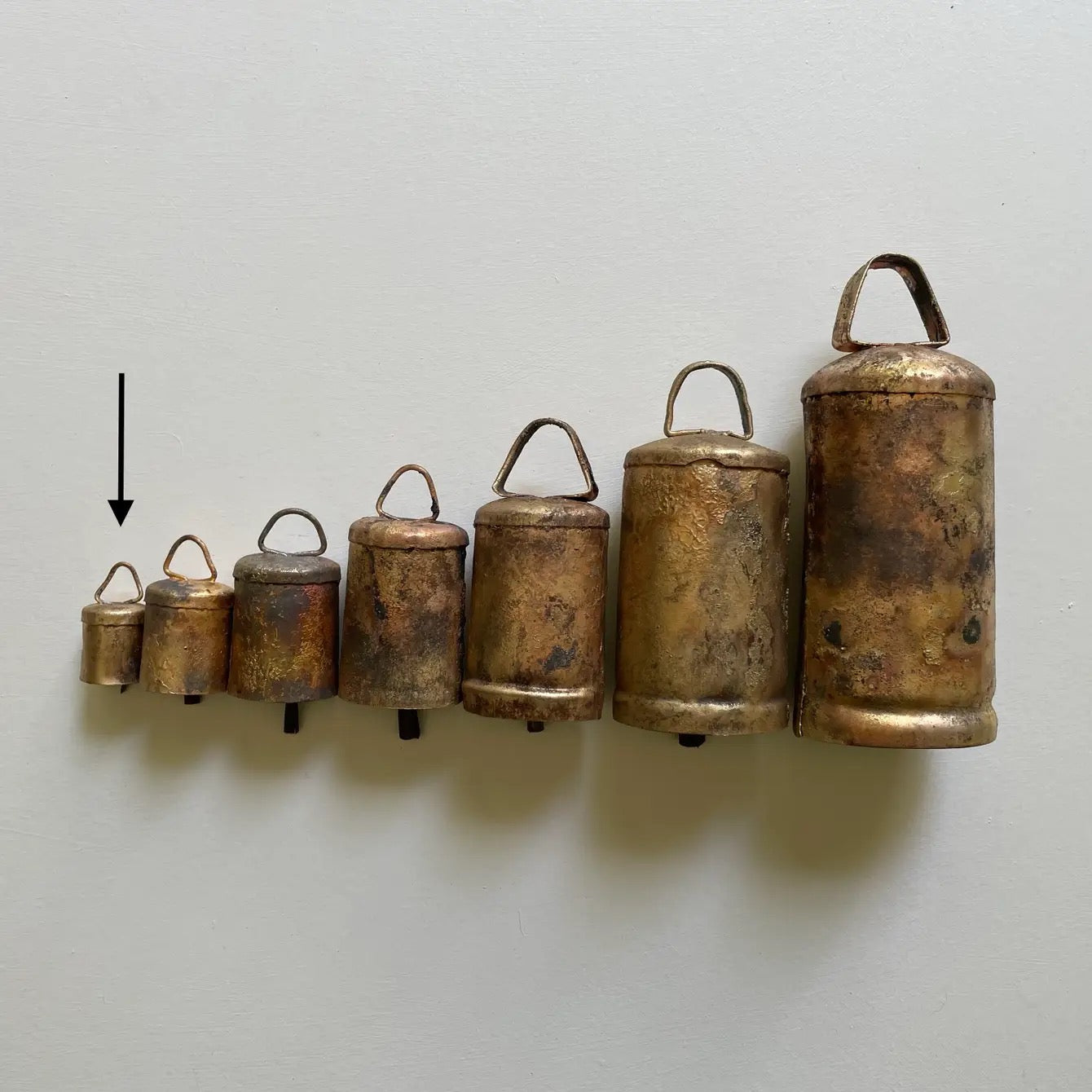 1 1/2 inch tiny flat top tin bells with brass finish and a metal striker with others to show size