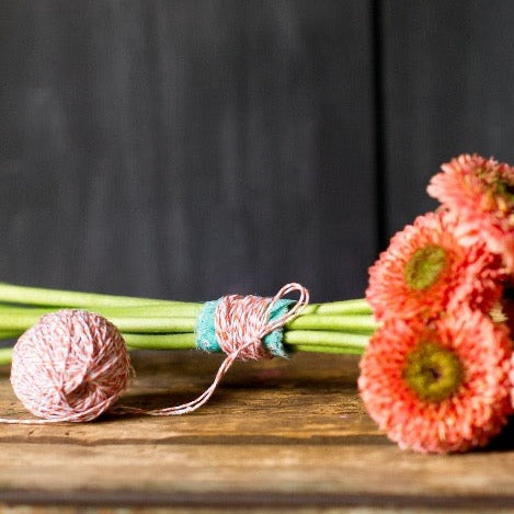 fresh cut flowers wrapped with red and white striped bakers twine