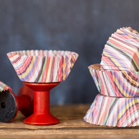 multicolored striped paper cupcake liners for a circus party supplies