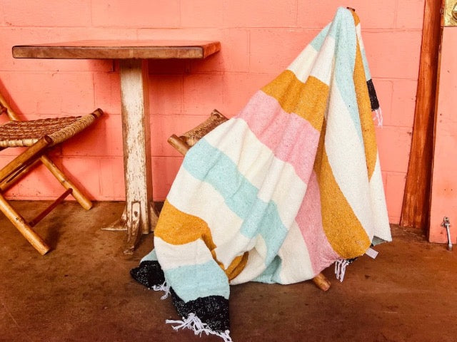 desert striped Mexican fringed throw blanket in hues of mustard, blush, turquoise, cream, and black
