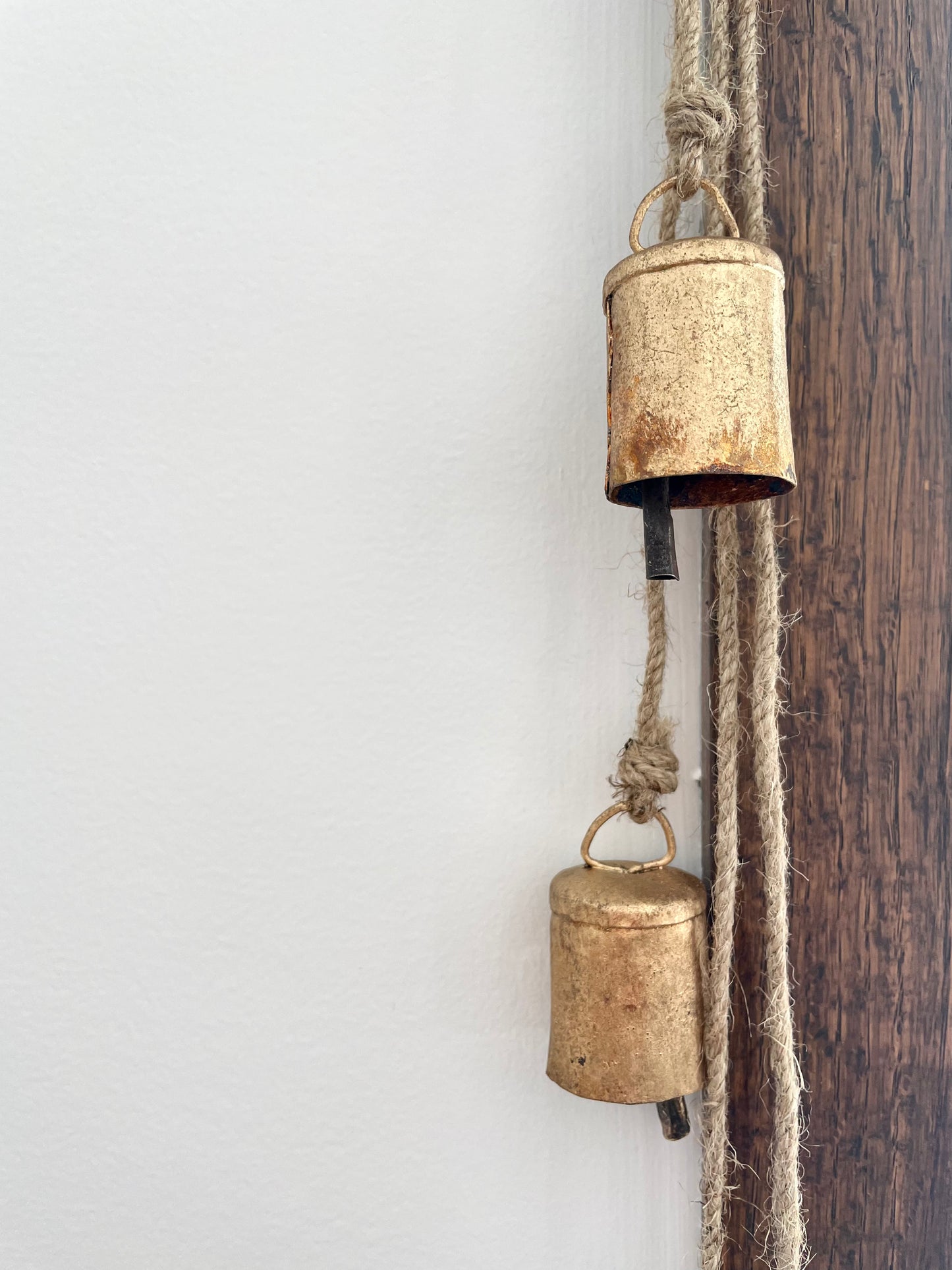 rustic brass finish cluster of 6 bells hanging on a jute string for holiday Christmas decor