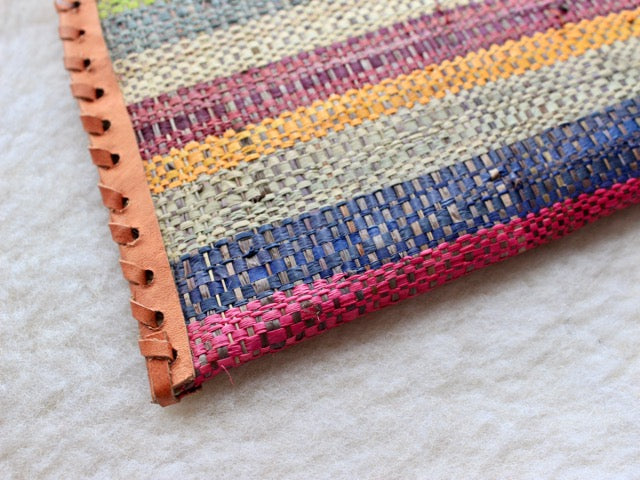 multi-colored muted striped raffia woven zippered clutch with leather trim bohemian