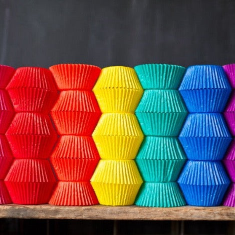 bright solid paper cupcake liners in a rainbow of colors for circus party supplies