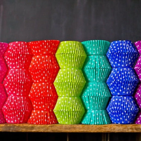 bright polka dot paper cupcake liners in a rainbow of colors for circus party supplies