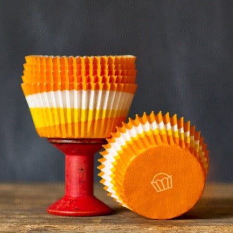 orange, yellow, and white paper cupcake liners for circus party supplies