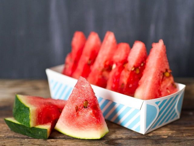 blue and white striped paper loaf baking pan with watermelon inside