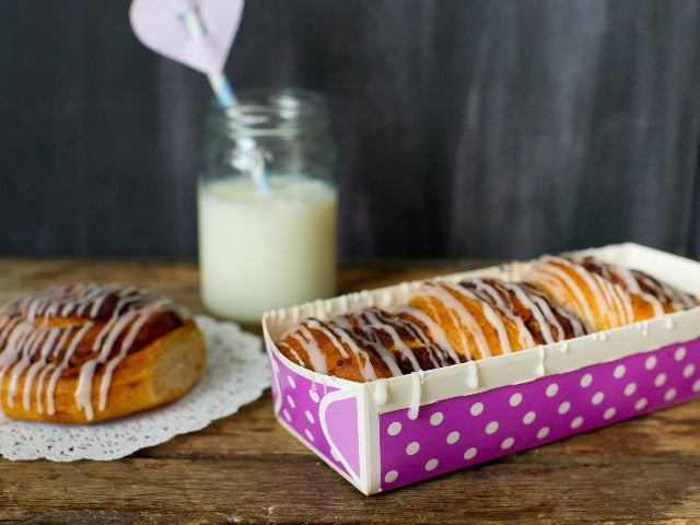 purple and white polka dot paper loaf baking pan with cinnamon rolls inside