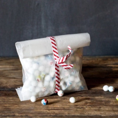 translucent white glassine bags in two sizes to package candy and wrap with striped red and white twist tie