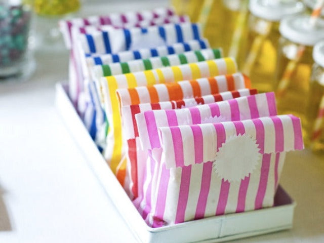 rainbow striped paper candy treat and gift favor bags with white starburst sticker label